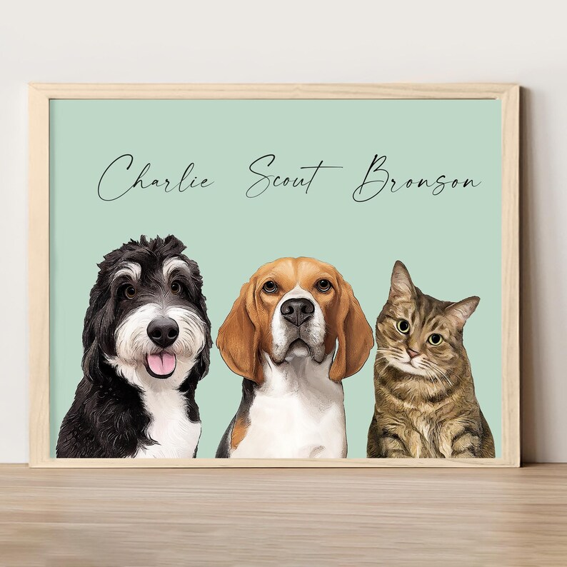 Pode incluir: Uma impress&atilde;o emoldurada com um fundo verde claro apresentando tr&ecirc;s retratos de animais de estima&ccedil;&atilde;o. Os retratos s&atilde;o de um c&atilde;o preto e branco chamado Charlie, um c&atilde;o marrom e branco chamado Scout e um gato tigrado chamado Bronson.