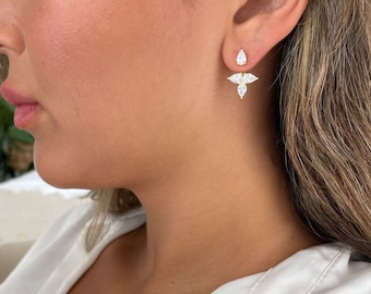 May include: Gold earrings with a teardrop-shaped stone and a cluster of smaller stones. The earrings are designed to be worn with the teardrop stone facing down.