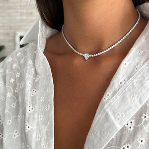Peut inclure: Un collier ras de cou argent&eacute; avec un pendentif en diamant de forme poire.