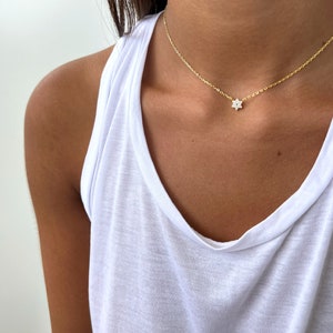 K&ouml;nnte beinhalten: Eine zarte goldene Kettenkette mit einem kleinen, funkelnden Sternanh&auml;nger.
