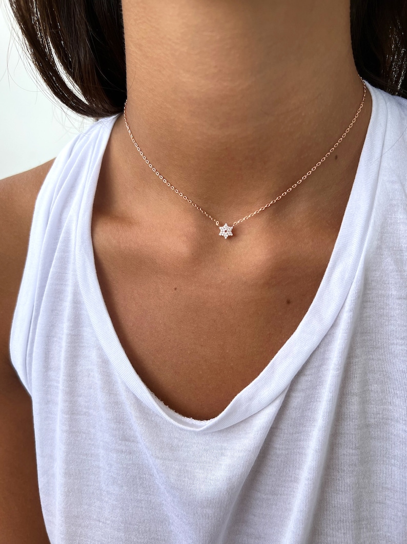 K&ouml;nnte beinhalten: Eine zarte Halskette aus ros&eacute;goldener Kette mit einem kleinen, funkelnden Sternanh&auml;nger.