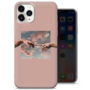 Puede incluir: Una funda transparente para tel&eacute;fono con fondo rosa y un gr&aacute;fico de dos manos que se alcanzan la una a la otra contra un cielo nublado.