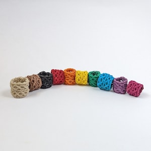 May include: A rainbow of colors in a set of 10 crocheted rings. The rings are made of a soft, textured yarn and are perfect for adding a pop of color to any outfit.