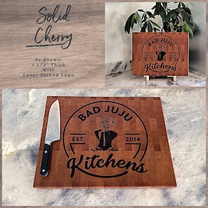 May include: A solid cherry wood cutting board with a laser-etched logo that says "Bad Juju Kitchens Est. 2014". The logo features a cartoon character with a mustache and a hat.