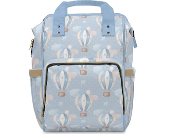 May include: A light blue backpack with a pattern of hot air balloons and clouds. The backpack has a large zippered pocket on the front and two adjustable straps.