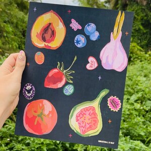 以下が含まれることがあります： 黒色の背景に、桃、イチゴ、トマト、イチジク、ニンニク、ブルーベリーのカラフルなイラストが描かれています。背景は星と、「Fly Fruit」、「Wasp Pollinated」、「Moth Pollinated」、「Bee Love」、「Beautifully Powerful」などのテキストが書かれたステッカーで飾られています。画像の下部には「Christina L. Mat」というテキストがあります