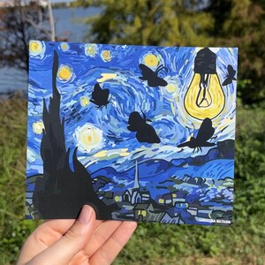 Peut inclure: Une peinture bleue et jaune d'un ciel nocturne &eacute;toil&eacute; avec une ampoule et des silhouettes de papillons. La peinture est intitul&eacute;e "Christina Watkins".