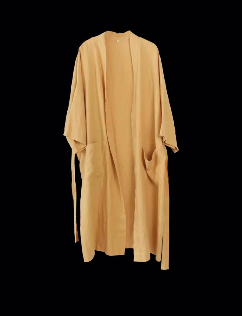 May include: A long, light yellow robe with a tie belt and two pockets. The robe is made of a soft, lightweight fabric.