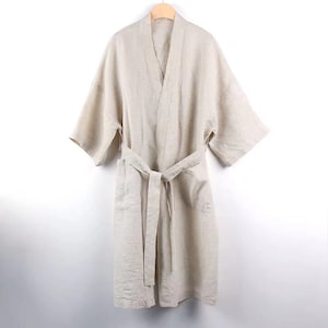 May include: A beige linen robe with a self-tie belt and long sleeves. The robe has a relaxed fit and is perfect for lounging around the house.