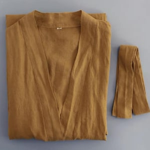 May include: A brown linen robe with a long tie belt. The robe has a V-neck and long sleeves.
