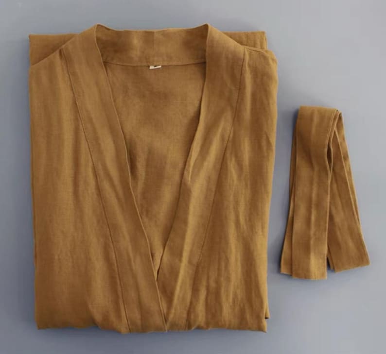 May include: A brown linen robe with a long tie belt. The robe has a V-neck and long sleeves.