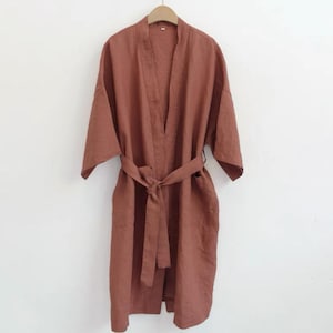 May include: A rust-coloured linen robe with a self-tie belt. The robe has a relaxed fit and is perfect for lounging around the house.