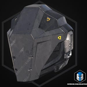 May include: A dark grey, angular piece of armour with a textured surface and yellow accents. The design features a geometric shape with visible wear and tear, suggesting a battle-worn aesthetic. The text "GALACTIC ARMORY" is visible.