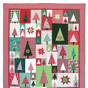 May include: A patchwork quilt pattern called "Pine Hollow Patchwork Forest" by Amy Smart. The quilt features a variety of green, red, and white Christmas trees in a grid pattern. The quilt is surrounded by a red and white gingham border.