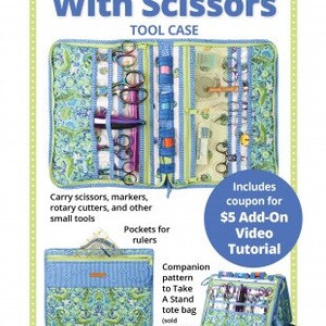 May include: A blue and green fabric tool case with multiple pockets and compartments for carrying scissors, markers, rotary cutters, and other small tools. The case is open to show the interior. The text "Running With Scissors Tool Case" is at the top of the image. The text "Includes coupon for $5 Add-On Video Tutorial" is in a yellow circle at the bottom right of the image.