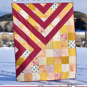May include: A quilt pattern called "Crossroads" featuring a red and yellow geometric design. The quilt is made with a variety of fabrics and is displayed against a snowy background. The quilt is made by Running Doe Quilts for Villa Rosa Designs.
