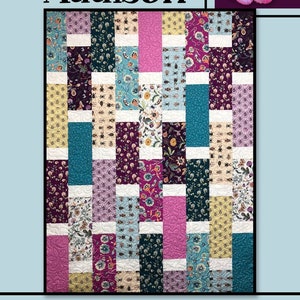 May include: A patchwork quilt with the name "Addison" at the top. The quilt features vertical strips of patterned fabric in various colors, including teal, pink, purple, and yellow. The quilt is made by Villa Rosa Designs.