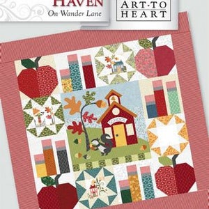 May include: A quilt block pattern featuring a schoolhouse, trees, apples, and books. The block is titled "Schoolhouse Haven" and is part of the "Art-to-Heart" collection. The block number is #9.