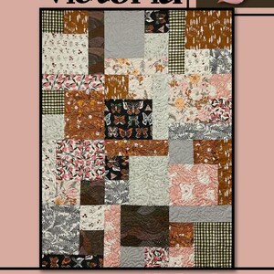 May include: A patchwork quilt with a variety of floral, butterfly, and geometric patterns in shades of brown, pink, and cream. The quilt features the text "Victoria" and "Villa Rosa Designs". A pink rose is in the upper right corner.
