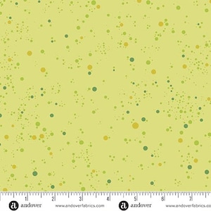 May include: A light yellow fabric with a pattern of scattered dots in shades of green and yellow. The dots vary in size and density, creating a textured appearance. The fabric is suitable for quilting and crafting.