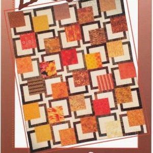 May include: A quilt pattern called "Maple Island" by "Quints" featuring a geometric design with squares of various colors and patterns, including orange, red, brown, and yellow.