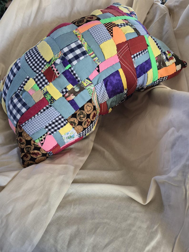 以下が含まれることがあります： ギンガムチェック、花柄、無地など、さまざまな色と柄のパッチワーク枕。 枕は丸みを帯びた形で、明るい緑色のストリップでアクセントがつけられています。 この装飾枕は、ユニークな家の装飾アイテムです。