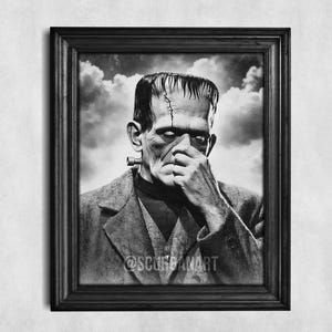 May include: Framed black and white print of Frankenstein's monster. The image shows the monster with a stitched scar, a neck bolt, and his hand near his face. The text "FRAME NOT INCLUDED" is at the bottom of the print. The background is a cloudy sky.