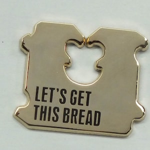 May include: Gold-colored metal bread bag clip with a cut-out shape in the center and the text "Let's Get This Bread".