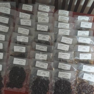 May include: A large quantity of individually packaged dried meat snacks. The packages are clear plastic and each has a white label with black text. The text on the label reads "8 oz. jerky, made with love, not preservatives".