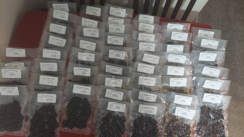 May include: A large quantity of individually packaged dried meat snacks. The packages are clear plastic and each has a white label with black text. The text on the label reads "8 oz. jerky, made with love, not preservatives".