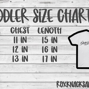 May include: A toddler size chart with measurements in inches for chest and length. The chart shows sizes 2T, 3T, and 4T. The chart is on a white wood background.