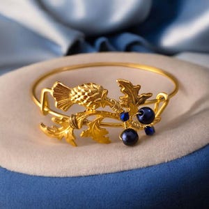 Brazalete de cardo dorado con perlas y cristales azul oscuro