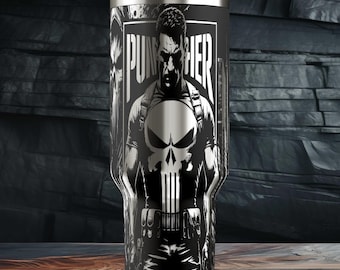 Könnte beinhalten: Ein schwarz-silberner Becher mit einer Grafik von The Punisher. Das Design beinhaltet den Punisher-Schädel und den Namen der Figur. Der Becher hat einen weißen Deckel und einen Strohhalm.