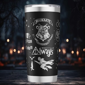 Puede incluir: Vaso térmico negro y plateado con gráficos blancos de Harry Potter, incluyendo el escudo de Hogwarts y la palabra "Always". El vaso tiene un borde y una base plateados.