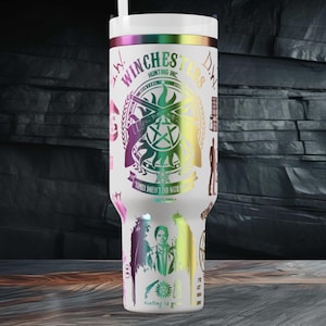 Può includere: Bicchiere bianco con un design iridescente arcobaleno. Il bicchiere presenta il testo "Winches Hunting Inc." e altre grafiche. Una cannuccia bianca è inserita nel coperchio. Il bicchiere è cilindrico e sembra essere in acciaio inossidabile.