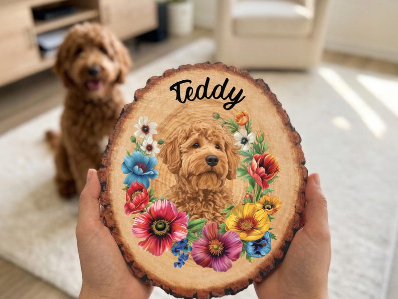May include: A wooden slice featuring a portrait of a dog named Teddy, surrounded by a floral wreath. The dog is a light brown color, and the flowers are in shades of red, blue, yellow, and purple. The name "Teddy" is written in black script.