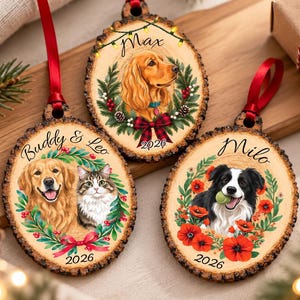 Könnte beinhalten: Drei ovale Holzanhänger mit Rindenkanten und roten Bändern. Jedes Stück zeigt eine individuelle Illustration von Haustieren, darunter ein Golden Retriever, eine getigerte Katze, ein Spaniel und ein Border Collie, umgeben von Blumenkränzen und der Jahreszahl 2026.