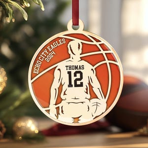 May include: Gold basketball bauble featuring a player silhouette, a basketball, and the text "Echo City Eagles 2024" and "Thomas 12".