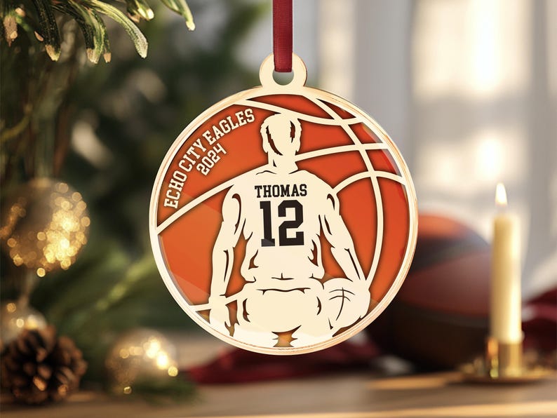 May include: Gold basketball bauble featuring a player silhouette, a basketball, and the text "Echo City Eagles 2024" and "Thomas 12".
