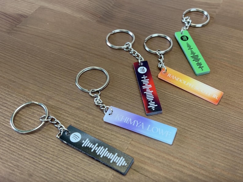 May include: Five keychains with different colored backgrounds and a Spotify barcode design. The keychains are labeled "Random", "Shimiya Love", "Love", "Random", and "Love".