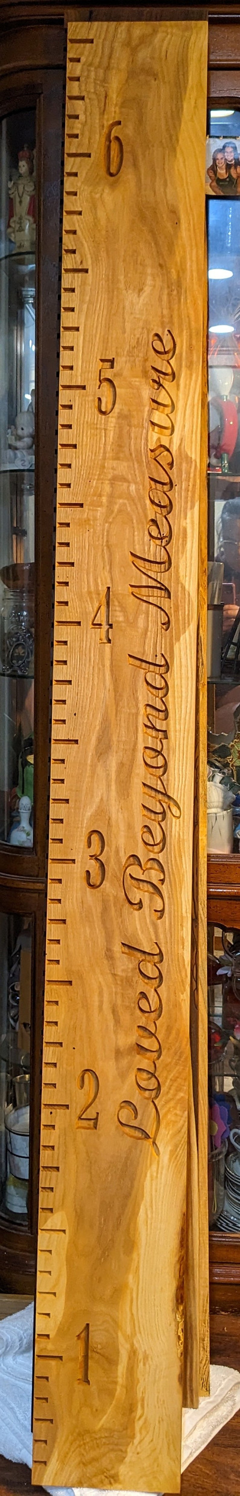 May include: A wooden growth chart with a ruler on the left side and the words "Past, Present, Future" carved into the wood.