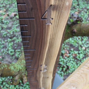 May include: A wooden growth chart with a dark brown stain. The chart has a ruler with markings and the number "4" carved into the wood.