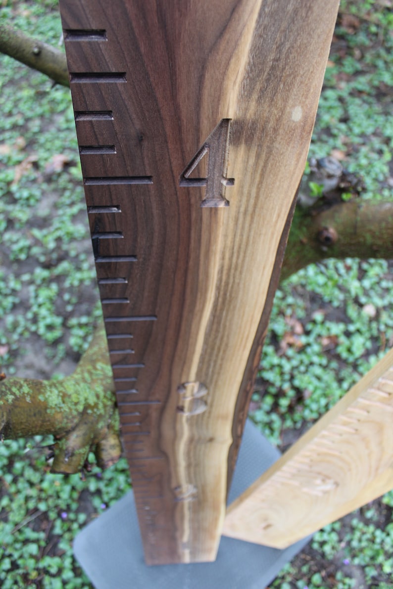 May include: A wooden growth chart with a dark brown stain. The chart has a ruler with markings and the number "4" carved into the wood.