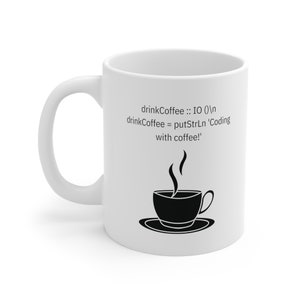 Może przedstawiać: Biały kubek ceramiczny z czarną sylwetką filiżanki kawy i pary. Kubek ma napis: "drinkCoffee :: IO ()
 drinkCoffee = putStrLn 'Coding with coffee!'".