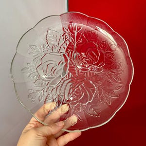 May include: A clear glass serving plate with an etched design of roses and leaves.
