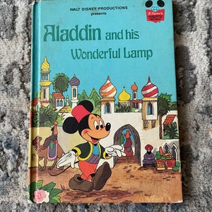 May include: A vintage children's book cover featuring Mickey Mouse dressed as Aladdin, with the title "Aladdin and his Wonderful Lamp" and the Walt Disney Productions logo.
