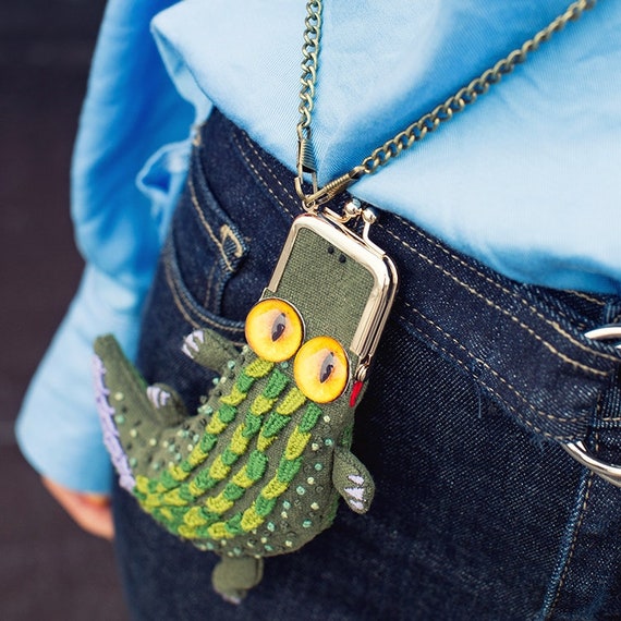 A wildly popular DIY needlepoint kit shaped like a crocodile bag — the 1,065 favorites prove people go absolutely nuts for this delightfully absurd craft project.