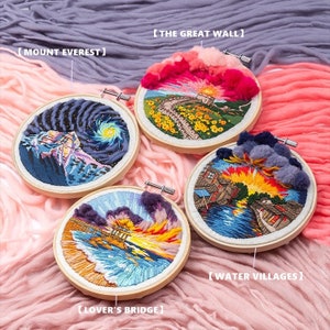 Pode incluir: Quatro aros de bordado com fio colorido que representam diferentes cenas: o Monte Everest, a Grande Muralha da China, uma aldeia aquática e uma ponte. Os aros são exibidos em um fundo rosa e roxo.