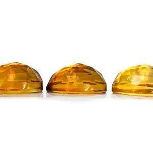 Yellow citrine gemstone cabochons.  Three rose cut cabochon stones seen from the side to demonstrate thick, high dome on stones.