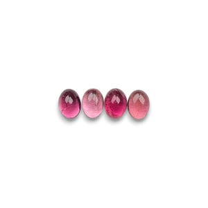 Pink tourmaline gemstone cabochons seen in light- to dark-pink.  Four smooth cut oval cabochon stones size 8 x 6 mm seen from the top.